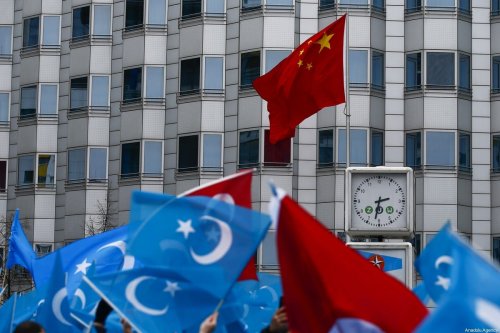 Demonstrators hold Uyghur flags as they take part in a demonstration in support of Uyghur Turks against human rights violations of China, in Berlin, Germany on 27 December 2019 [Abdulhamid Hoşbaş/Anadolu Agency]