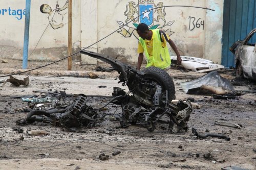 Crime scene officials inspect the suicide car bombing area in Mogadishu, Somalia on September 25, 2021 [Sadak Mohammed/Anadolu Agency]