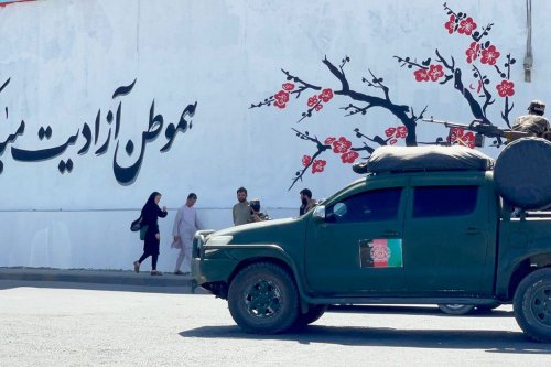 Taliban stand guard in front of US Embassy as walls painted with Taliban flag in Kabul, Afghanistan on September 8, 2021 [Haroon Sabawoon / Anadolu Agency]