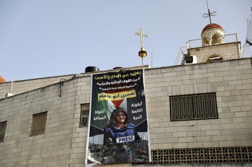 A banner of slain Al-Jazeera journalist Shireen Abu Akleh hung on the church in East Jerusalem on 12 May 2022 [Mostafa Alkharouf/Anadolu Agency]