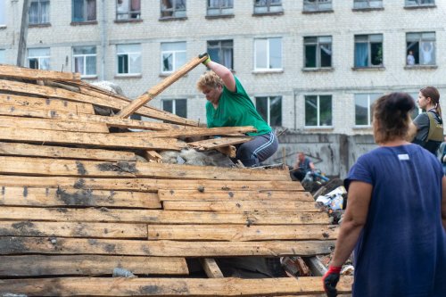 KHARKIV, UKRAINE – JULY 10: Local residents clean up the rubbles and debris after a Russian missile strike in the south of Kharkiv, Ukraine on July 10, 2022. ( Sofia Bobok - Anadolu Agency )