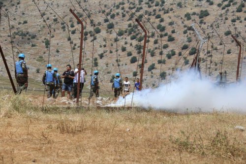 People gather to protest after an Israeli army bulldozer digs a ditch on the Lebanese border in Kafr Shuba region of southern Lebanon on June 11, 2023 [Ramiz Dallah - Anadolu Agency]