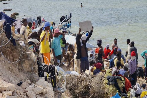 African irregular migrants, including children, wait under the sun near the Ras Ajdir border crossing in the region close to Libya's Tunisian border, on July 26, 2023 [Hazem Turkia - Anadolu Agency]