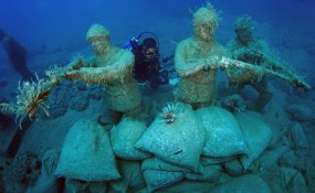 A diver swims around an underwater statue at the Side Underwater Museum, Turkiye's first underwater museum, in Manavgat district of Antalya, Turkiye on June 19, 2023. [Tahsin Ceylan - Anadolu Agency]