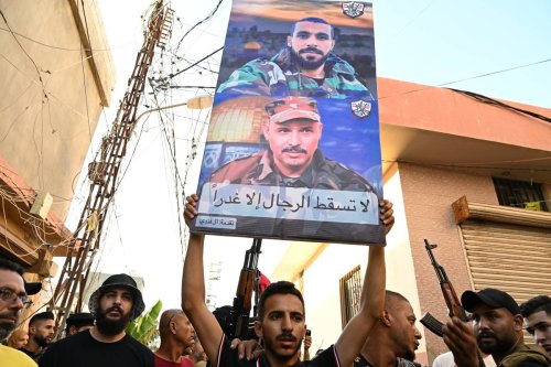 A man holds a poster among the people gathered for the funeral ceremony of Fatah Movement members and 3 guards in Sidon, Lebanon on July 31, 2023 [Houssam Shbaro/Anadolu Agency]