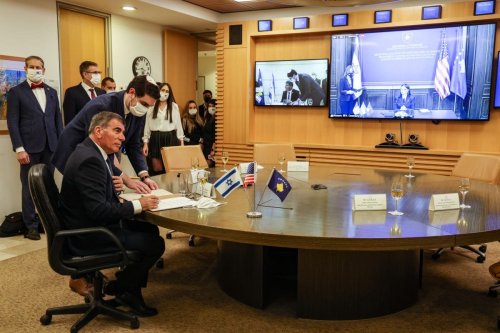Israel's Foreign Minister Gabi Ashkenazi (L) signs a joint declaration establishing ties with Kosovo during an official ceremony held over Zoom with his counterpart from Kosovo Meliza Haradinaj Stublla (screen), at the Israeli Foreign Ministry headquarters in Jerusalem on February 1, 2021 [MENAHEM KAHANA/AFP via Getty Images]