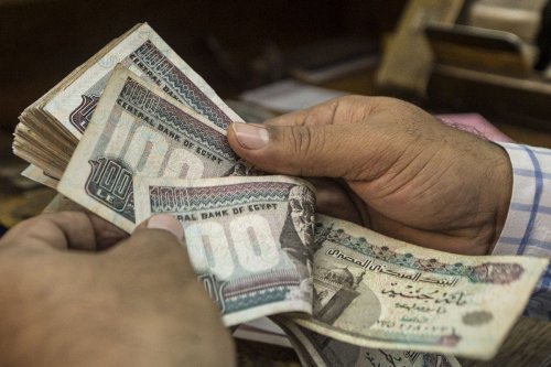 A man counts Egyptian pounds at currency exchange shop in downtown Cairo on 3 November 2016 [KHALED DESOUKI/AFP/Getty Images]
