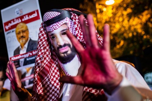A protestor wears a mask of depicting Saudi Crown Prince Mohammad Bin Salman next to posters of the murdered Saudi journalist Jamal Khashoggi on 25 October 2018 [YASIN AKGUL/AFP/Getty Images]
