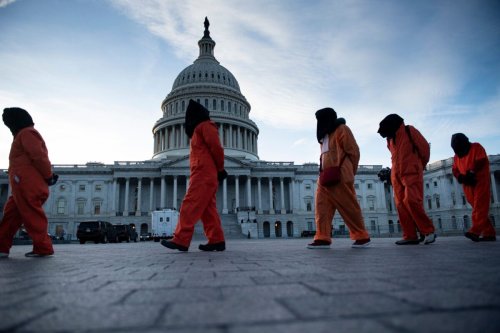 Demonstrators dressed in Guantanamo Bay prisoner uniforms march past Capitol Hill in Washington, DC, on January 9, 2020, during a rally on "No War with Iran." (Photo by Brendan Smialowski / AFP) (Photo by BRENDAN SMIALOWSKI/AFP via Getty Images)