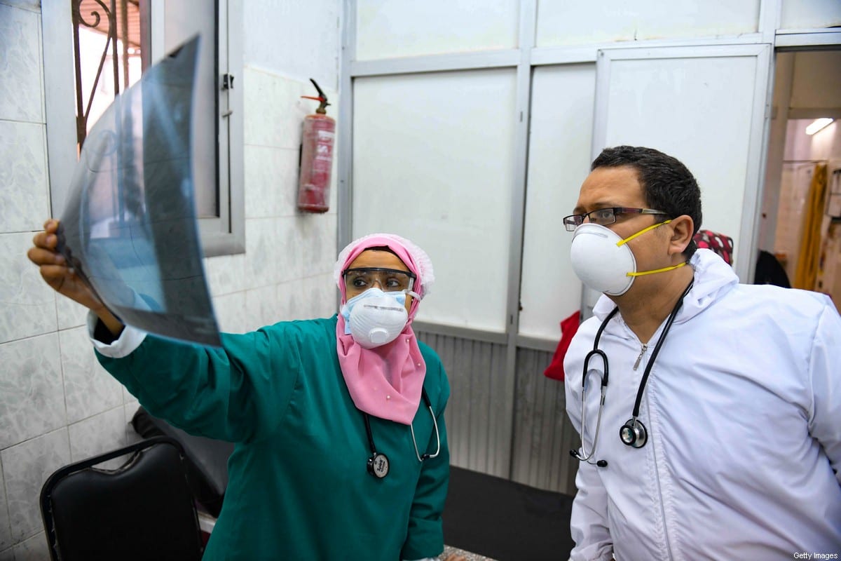 Egyptian doctors check a patient's lung X-ray at the infectious diseases unit of the Imbaba hospital in the capital Cairo, on April 19,2020, during the novel coronavirus pandemic crisis [AHMED HASAN/AFP via Getty Images]