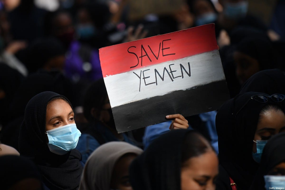 A protester holds a Yemeni flag-themed placard in Parliament Square in London on 5 July 2020, as she demonstrates against the continued conflict in Yemen. [JUSTIN TALLIS/AFP via Getty Images]