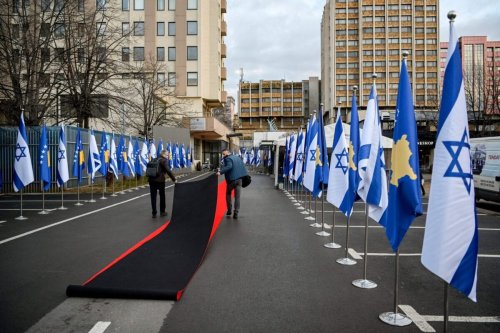 Workers drag the red carpet next to Kosovo's and Israel's flags displayed during a ceremony at the headquarters of the Foreign Ministry in Pristina on February 1, 2021. - Kosovo and Israel established diplomatic ties on February 1, 2021, with the Muslim-majority territory recognising Jerusalem as the Jewish state's capital, putting it at odds with the rest of the Islamic world. In a ceremony held over Zoom in Jerusalem and Pristina, Israeli Foreign Minister and his counterpart from Kosovo signed a joint declaration establishing ties. (Photo by Armend NIMANI / AFP) (Photo by ARMEND NIMANI/AFP via Getty Images)