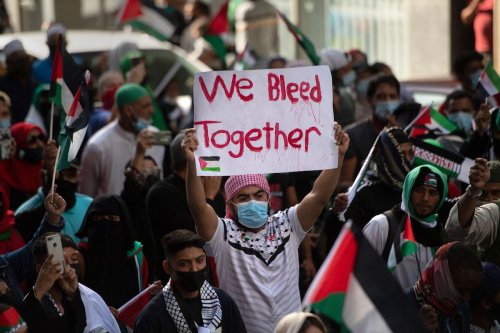 A demonstrator holds a placard as they march through the city centre in Cape Town, on 12 May 2021 during a protest against Israeli attacks on Palestinians in Gaza [RODGER BOSCH/AFP via Getty Images]