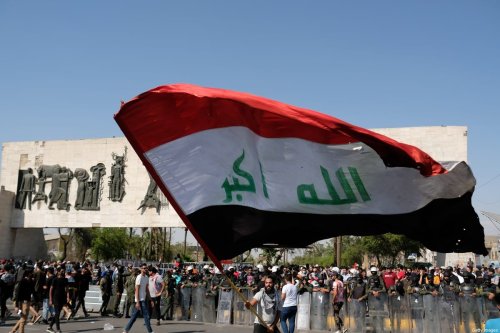 Iraqis waving the Iraqi flag in Al Tahrir Square on May 25, 2021 in Baghdad, Iraq [Taha Hussein Ali/Getty Images]