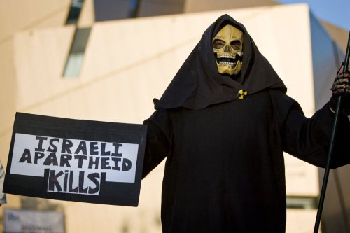 US left-wing activist protests against the construction of settlements in the West Bank outside the Bar Ilan university in Ramat Gan, near Tel Aviv, as Prime Minister Benjamin Netanyahu gave a keynote address in which he laid out his peace policy on June 14, 2009 [JONATHAN NACKSTRAND/AFP via Getty Images]