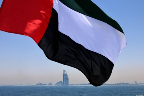 Emirati flag fluttering above Dubai's marina with the Burj Al Arab landmark hotel in the background [KARIM SAHIB/AFP via Getty Images]