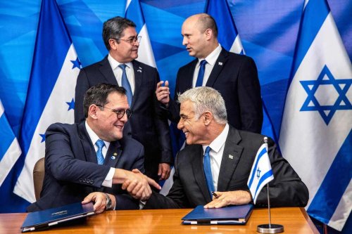 Israeli Foreign Minister Yair Lapid (bottom R) shakes hands with Honduran Foreign Minister Lisandro (bottom L) as Israeli Prime Minister Naftali Bennett (top R) speaks with Honduran President Juan Orlando Hernandez (top L) during the signing of bilateral agreements at the Prime Minister's Office in Jerusalem on 24 June 2021. [HEIDI LEVINE/AFP via Getty Images]