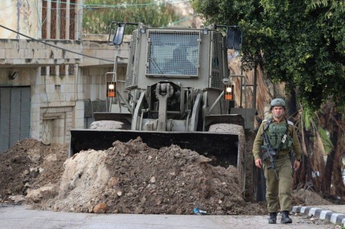 Israeli security forces block the entrances to the West Bank village of Burqah, near the illegal Israeli outpost Homesh, ahead of a protest by Israeli settlers on December 23, 2021 [JAAFAR ASHTIYEH/AFP via Getty Images]