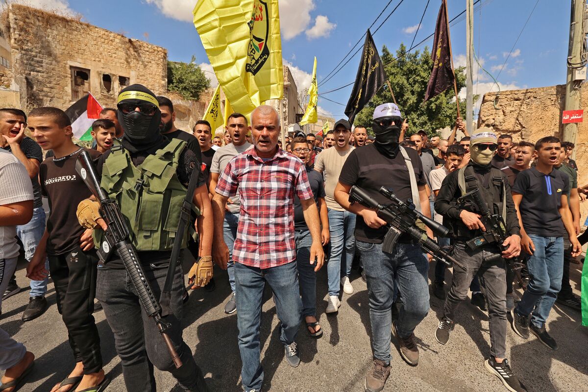 Palestinian fighters and civilians march in the village of Kafr Dan, to show solidarity with the families of 2 Palestinians killed in overnight clashes with Israeli security forces near a checkpoint inorth of the occupied West Bank town of Jenin, on September 14, 2022 [Photo by JAAFAR ASHTIYEH/AFP via Getty Images]