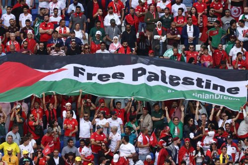 Fans hold a Flag of Palestine with Free Palestine written on it during the FIFA World Cup Qatar 2022 Group D match between Tunisia and Australia at Al Janoub Stadium in Al Wakrah, Qatar. [Photo by James Williamson - AMA/Getty Images]