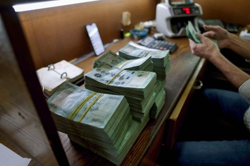 A clerk counts banknotes at a currency exchange office in Lebanon's capital Beirut, [JOSEPH EID/AFP via Getty Images]