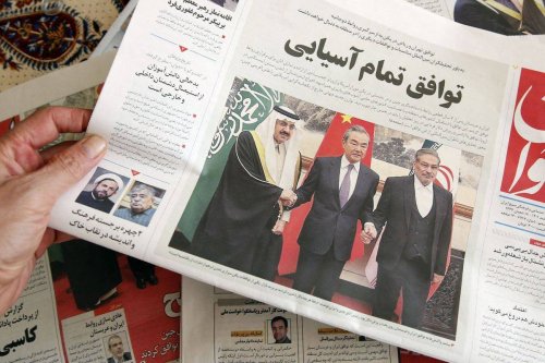 A man in Tehran holds a local newspaper reporting on its front page the China-brokered deal between Iran and Saudi Arabia to restore ties, signed in Beijing the previous day, on March, 11 2023. [ ATTA KENARE/AFP via Getty Images]