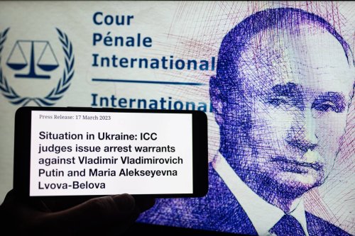 Vladimir Putin arrest warrant seen in press release from the International Criminal Court in The Hague. On 17 March 2023 in Brussels, Belgium. [Photo Illustration by Jonathan Raa/NurPhoto via Getty Images]