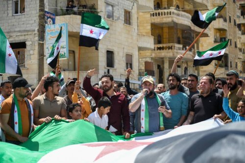 Syrian opposition protesters rally in the city of Afrin, northwest of Syria, condemning the Arab League's initiative to invite the Syrian regime's head, Bashar al-Assad, to attend their summit on May 19, 2023. [Photo by Rami Alsayed/NurPhoto via Getty Images]
