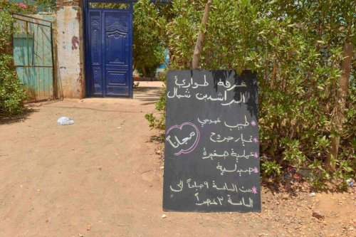A placard announces working hours of a makeshift emergency room set-up by Sudanese volunteers in a school building in Omdurman, the capital's twin city, on May 27, 2023 [AFP via Getty Images]