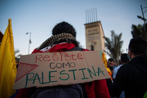 A demonstrator with a sign that reads 'Resist like Palestine' in Bogota, Colombia on May 19, 2021 [Chepa Beltran/Long Visual Press/Universal Images Group via Getty Images]