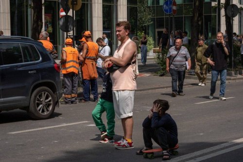 A man with children near a four-story residential building hit by a missile on July 6, 2023 in Lviv, Ukraine [Iva Sidash/Global Images Ukraine via Getty Images]