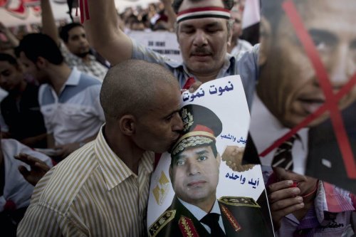 An Egyptian man kisses a picture of General Abdel Fattah al-Sisi in a pro-Sisi protest in Tahrir Square on July 7, 2013 in Cairo, Egypt. [Carsten Koall/Getty Images]