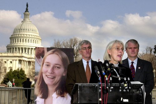 Cynthia Corrie (C) speaks next to her husband Craig Corrie (L) and US Representative Brian Baird (D-WA) (R), next to a picture of her daughter peace activist Rachel Corrie March 19, 2003 in Washington, DC [Stefan Zaklin/Getty Images]