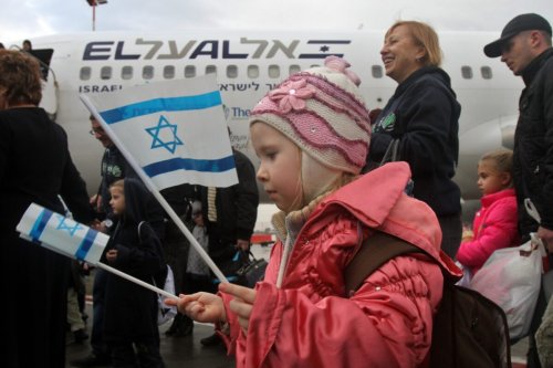 Jewish new immigrants from Ukraine, who are making Aliyah (Immigration to Israel), walk on the tarmac after landing at Ben Gurion International airport [GIL COHEN-MAGEN/AFP via Getty Images]