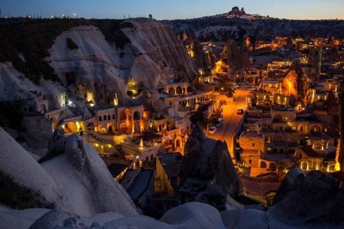Light illuminates cave hotels at sunset in the town of Goreme on April 17, 2016 in Nevsehir, Turkey [Chris McGrath/Getty Images]