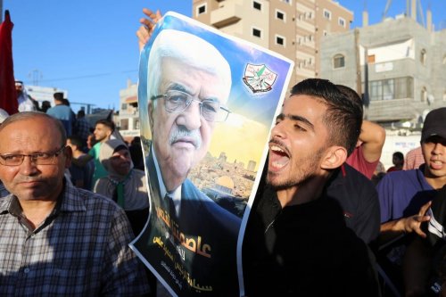 Palestinians carry pictures of Palestinian President Mahmoud Abbas during a protest in Gaza on 20 August 2020 [Ashraf Amra/ApaImages]