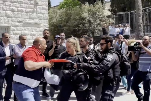 Israeli officers remove Palestine flag during slain journalist's funeral