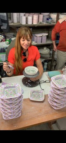 Elizabeth Kassis is painting on ceramic