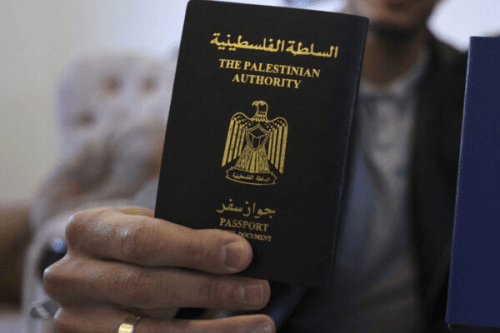 An image of a Palestinian man holding a passport, in the central Gaza Strip on March 22, 2022 [SAID KHATIB/AFP via Getty Images]
